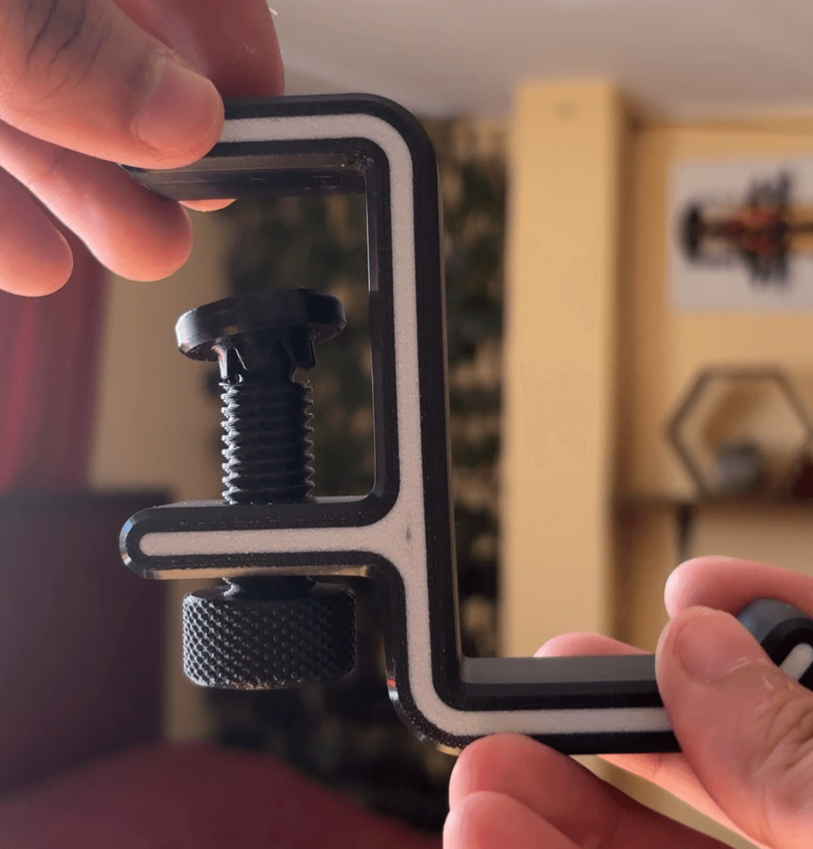 Porta auriculares de pinza sujeto al borde de un monitor